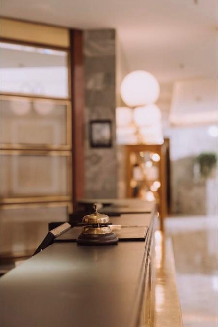 Recepción de hotel con campana de servicio sobre el mesón